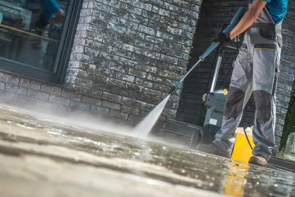 An image of a person pressure washing tiles outside on the floor and making them spotless. This shows the pressure washing services that RSM Property Solutions provide.